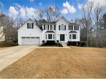 Two-story white house with a three-car garage and landscaped lawn at 7045 Treeline Dr, Cumming, GA 30028