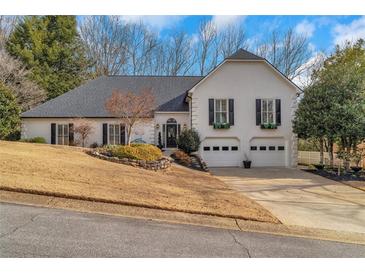 Charming two-story home boasts a well-manicured lawn, beautiful landscaping, and a convenient two-car garage at 4440 Ormond Ne Trce, Marietta, GA 30066