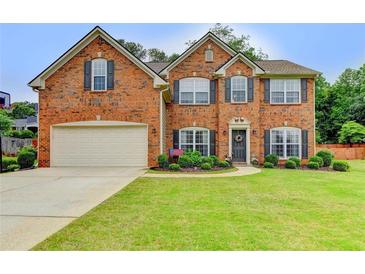 Charming two-story brick home with a well-manicured lawn and a two-car garage at 600 Beckenham Walk Dr, Dacula, GA 30019