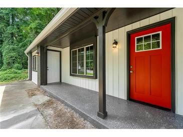 Inviting front porch with a bright red door and dark trim, offering a charming entrance to the home at 1428 Muirfield Dr, Stone Mountain, GA 30088