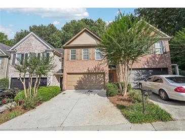 Brick front of townhome with 2-car garage and landscaping at 718 Surrey Park Se Pl, Smyrna, GA 30082