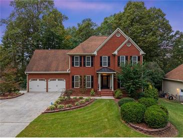 Brick two-story house with a two-car garage and landscaped yard at 561 Congress Pkwy, Lawrenceville, GA 30044