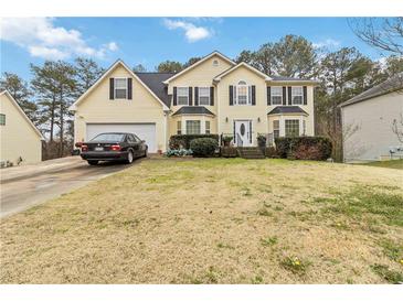 Two-story house with attached garage and landscaped lawn at 7483 Pleasant Hill Rd, Lithonia, GA 30058