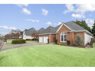 Charming brick home featuring a well-manicured lawn and attached two-car garage at 2224 Snug Ne Hbr, Marietta, GA 30066