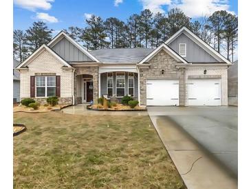 Charming single-story home featuring a well-manicured lawn and attached two-car garage at 7417 Jennadee Dr, Fairburn, GA 30213