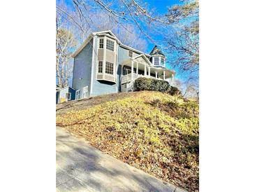 Charming blue two-story home with a large wrap-around porch and beautiful bay windows at 2610 Woodridge Chase, Canton, GA 30114