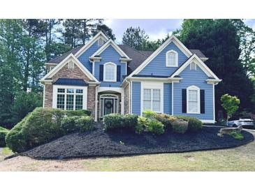Beautiful blue two-story home with brick accents and a well-manicured front yard at 3390 Vista Creek Dr, Dacula, GA 30019