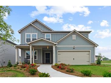 Two-story house with gray siding, beige garage door, and landscaping at 3152 Birdsong Ave, Covington, GA 30016