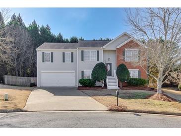 Charming two-story home with a brick facade, gray siding, well-manicured landscaping, and a two car garage at 102 River Marsh Ln, Woodstock, GA 30188