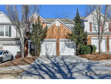 Brick front of townhome with 2-car garage and landscaping at 2029 Polesdean Trce, Duluth, GA 30097