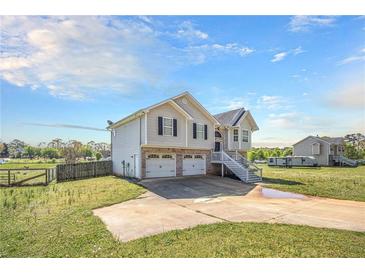 Charming two-story home with a two-car garage and steps leading to the front door under a blue sky at 1165 Hardin Bridge Rd, Euharlee, GA 30145