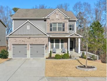 Two-story brick home with gray siding, two-car garage, and landscaped yard at 1868 Lakeview Bend Way, Buford, GA 30519