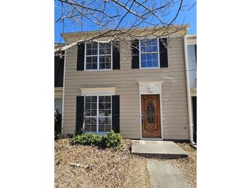 Tan two-story townhouse with black shutters and a wood door at 3140 Shadow Walk Ln, Tucker, GA 30084