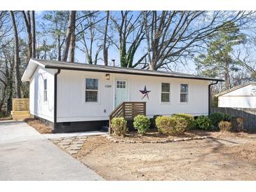 Charming white house with a green door and stone pathway at 1084 Fairburn Nw Rd, Atlanta, GA 30331
