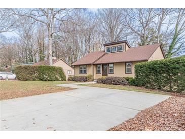Traditional single-Gathering home featuring a large driveway and mature landscaping at 3847 Admiral Dr, Chamblee, GA 30341