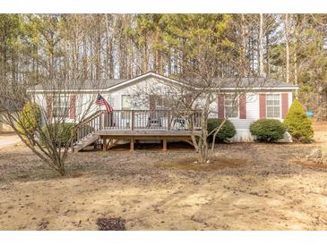 Single-wide manufactured home with a deck and American flag at 1050 Zion Church Rd, Dallas, GA 30157