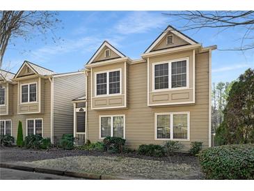 Tan two-story townhome with multiple windows and landscaping at 27 Lakes Edge Se Dr, Smyrna, GA 30080