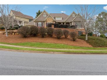 Charming two-story home featuring stone accents, lush landscaping, and a well-maintained yard at 100 Pine Sandy Bank Dr, Canton, GA 30114