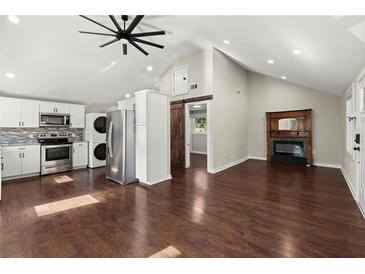 Open-concept living room featuring hardwood floors, fireplace, and modern kitchen appliances at 530 Bolton Nw Rd, Atlanta, GA 30331