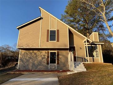 Charming home featuring unique architectural details, a well-manicured lawn, and a welcoming entrance at 1126 Mainstreet Valley Dr, Stone Mountain, GA 30088