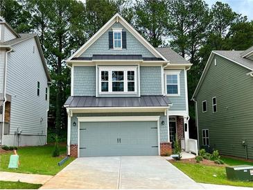 Charming two-story home with a two-car garage, a covered porch, and a beautifully landscaped front yard at 3335 Park Pointe Cir, Scottdale, GA 30079