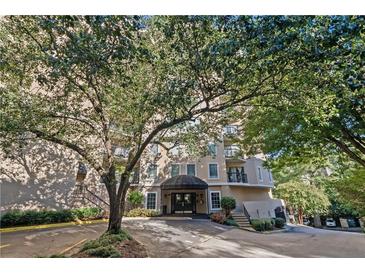 Elegant condo building exterior with a covered entrance and lush landscaping at 1 Biscayne Nw Dr # 809, Atlanta, GA 30309