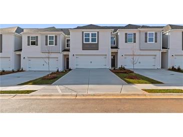 Modern townhome exterior showcasing neutral paint, individual garages, and manicured landscaping at 317 Heavenly Hollow Pl, Mcdonough, GA 30253