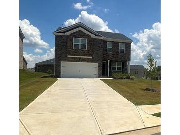 Two-story brick home with a large driveway and landscaped lawn at 266 Broder Farms Dr, Stockbridge, GA 30281