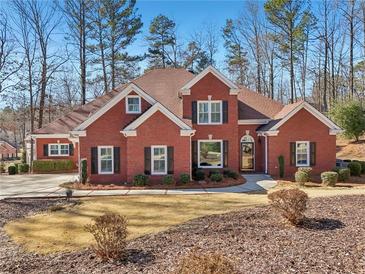 Brick house with a two-car garage and well-maintained landscaping at 4035 Powerscourt Pl, Suwanee, GA 30024