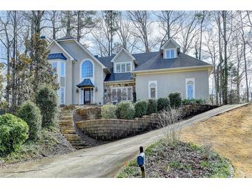 Charming two-story stucco home with a well-manicured lawn and mature trees at 976 Forest Pond Cir, Marietta, GA 30068