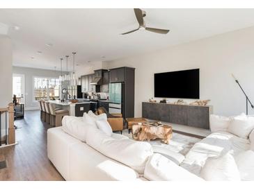 Open-concept living room showcasing a modern kitchen, hardwood floors, and ample natural light at 1371 Walking Way, Atlanta, GA 30316