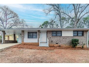 Charming single-story home featuring a brick facade, covered porch, and attached carport at 2600 Burkshire Rd, Ellenwood, GA 30294