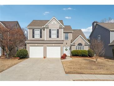 Charming two-story home featuring a well-maintained yard, two-car garage, and neutral color palette at 4035 Crabapple Lake Ct, Roswell, GA 30076