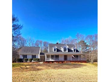 Charming home with a long front porch, well-manicured landscaping, and an expansive lawn at 866 Lee Byrd Rd, Loganville, GA 30052