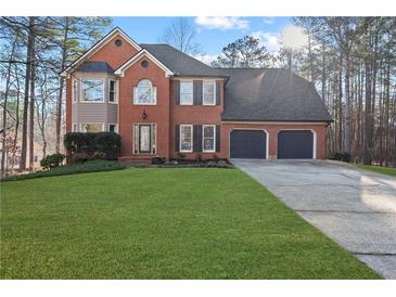 Two-story brick home with a three-car garage and well-manicured lawn at 1685 Bullard Rd, Powder Springs, GA 30127