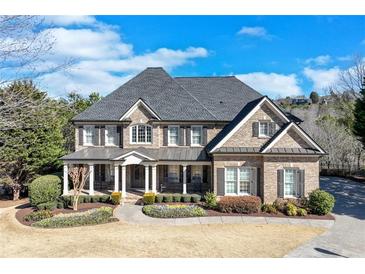 Traditional brick home with inviting front porch, manicured lawn, and tasteful landscaping at 2475 Gants Hill Pl, Cumming, GA 30041