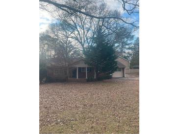 Traditional home featuring a covered front porch and a classic design with mature trees at 7205 Lakeview Dr, Covington, GA 30014