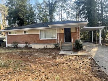 Brick ranch house with carport and landscaped yard at 1864 Cindy Dr, Decatur, GA 30032