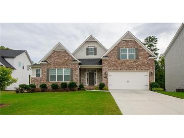 Charming brick home with a two-car garage and well-manicured front lawn at 4380 Serenity Lake Dr, Cumming, GA 30028
