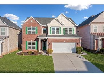 Brick two-story house with green shutters, a white door, and a two-car garage at 5819 Rue Chase Way, Tucker, GA 30084