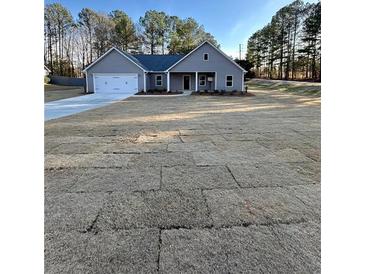 Charming single-story home with a manicured lawn and attached two-car garage at 3740 Cobblestone Dr, Loganville, GA 30052