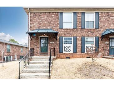 Charming brick townhome with steps leading to a covered front door and decorative shutters at 5672 Kingsport Dr # 4, Atlanta, GA 30342