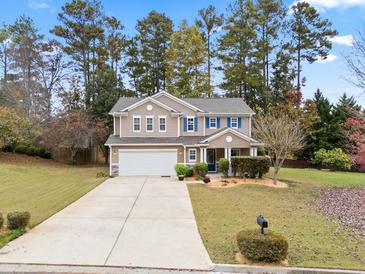 Charming two-story home featuring a two-car garage, manicured lawn, and mature trees at 296 Cedar Bay Cir, Dallas, GA 30157