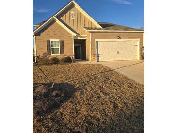 Tan house with white garage door and brown shutters at 35 Meriwether Dr, Villa Rica, GA 30180