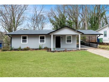 Single-story home with a well-maintained front yard, covered porch, and driveway at 327 Thornton Sw St, Atlanta, GA 30315