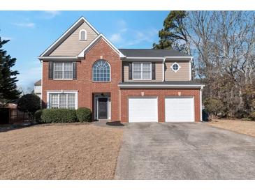 Charming two-story home featuring brick and siding, a two-car garage, and a well-manicured front lawn at 1348 Rolling Stream Way, Lawrenceville, GA 30043