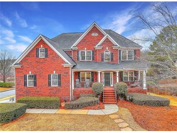 Charming brick two-story home with a welcoming front porch and manicured landscaping at 1510 Mount Mckinley Dr, Grayson, GA 30017