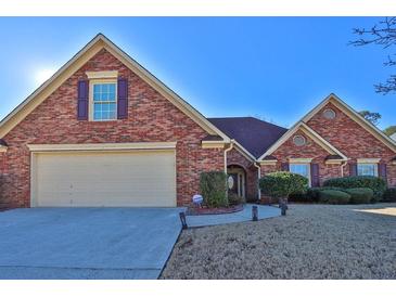 Charming brick home with a well-manicured lawn and attached two-car garage at 1070 River Valley Dr, Dacula, GA 30019