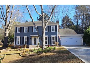 Charming two-story home featuring a well-manicured front yard and an attached two-car garage at 744 Dean Way, Lawrenceville, GA 30044