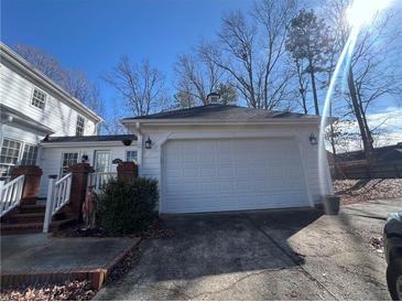 Attached two-car garage featuring paneled doors, carriage lights, and an asphalt driveway at 509 Arnold Rd, Lawrenceville, GA 30044